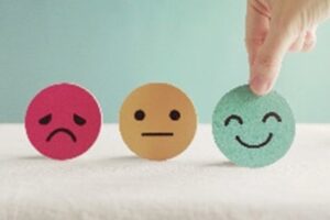 Image of emojis : smiling face, neural face and sad face
