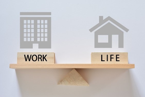 Image of a house with the word Life and image of an office building with the word Work standing on a scale