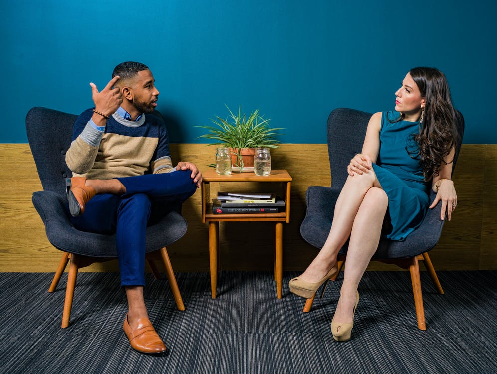 An image of two colleagues talking and seated side-by-side.