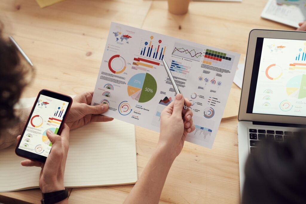 An image of two employees reviewing various data charts and tables.