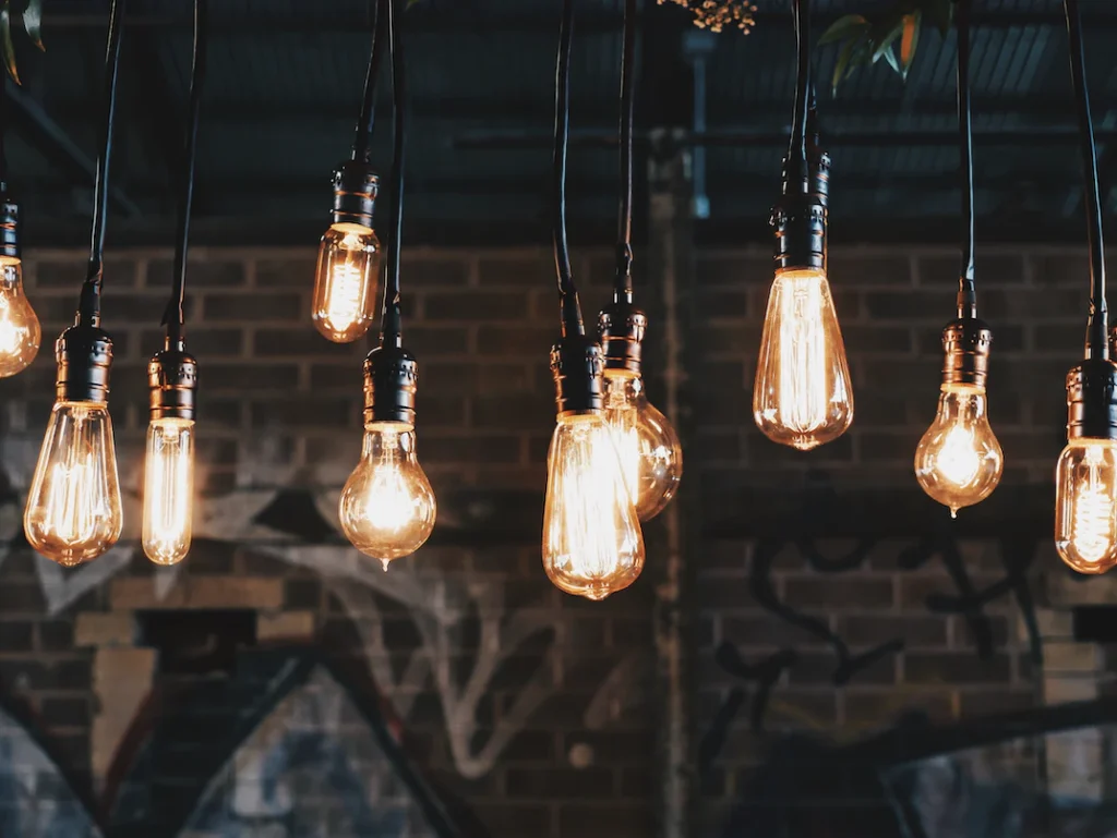 An image of several incandescent light bulbs hanging from the ceiling.