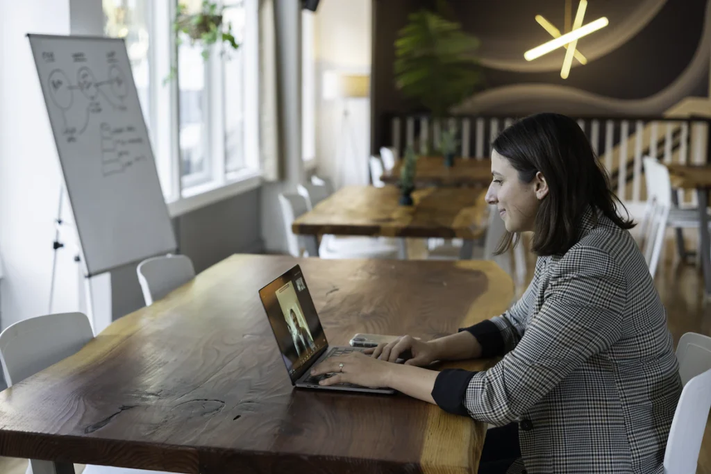 An image of an employee working in an office while in a virtual meeting with a remote colleague.