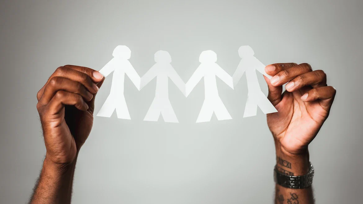 An image of a person holding up a banner representing people holding hands.