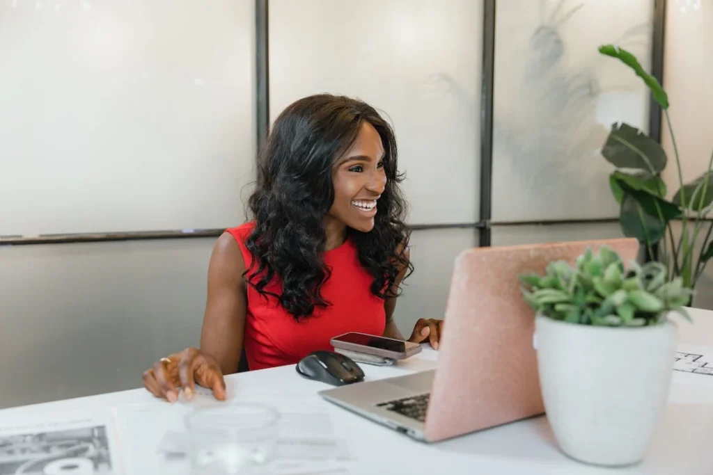 An image of an employee working on a laptop and smiling.