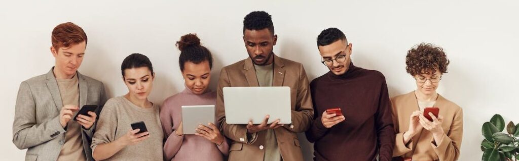 An image of six employees each working on different devices.