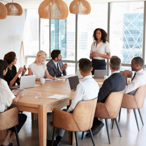 An image of 8 colleagues around a meeting table.