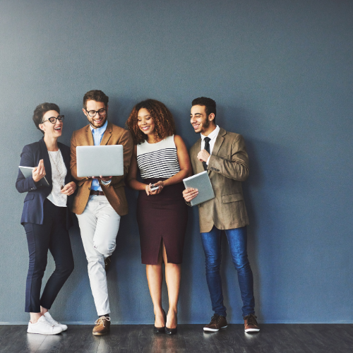 An image of 4 colleagues smiling and looking at a laptop screen.