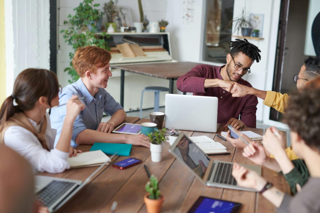 An image of colleagues working together around a table.