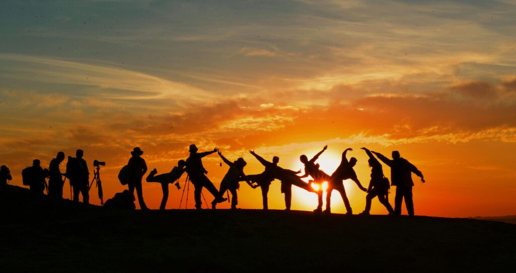 an image of people on a mountain top at sunset